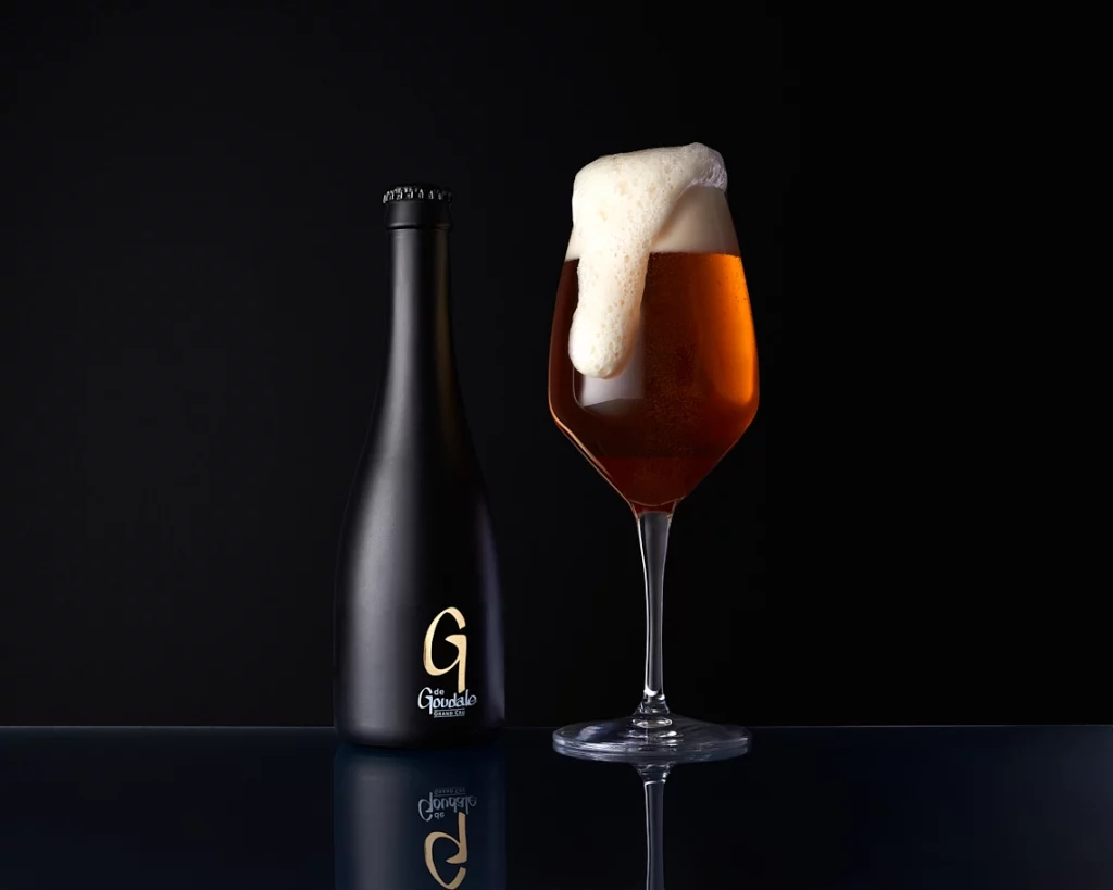 Photographie d'un verre à vin où la bière déborde, sur fond noir - Photographe publicitaire boissons - photographe e-commerce - photographe commercial - Aurore Aivrest