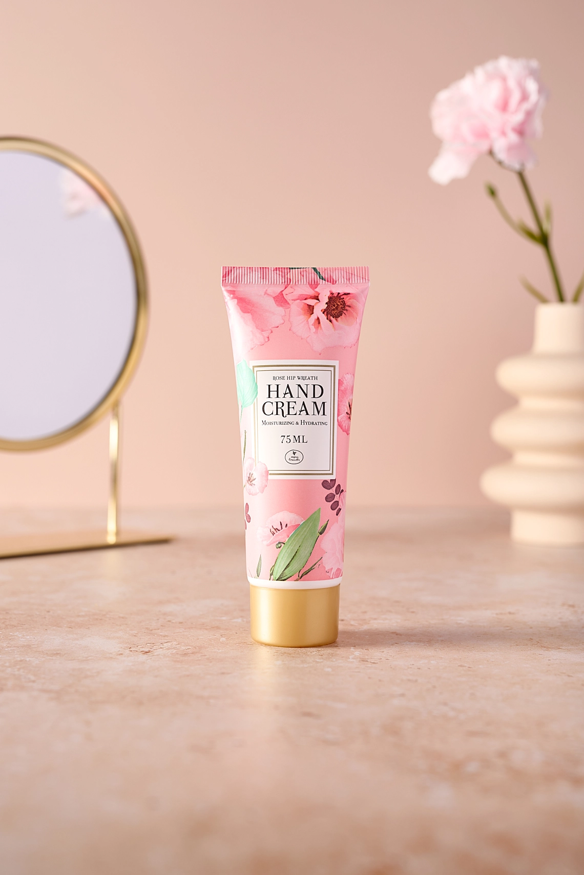 Photographie d'une crème pour les mains rose dans un decor féminin avec de la pierre et des tons beiges et rose poudre - Photographe cosmétique - photographe lifestyle cosmétique - photographe produits cosmétiques - Aurore Aivrest