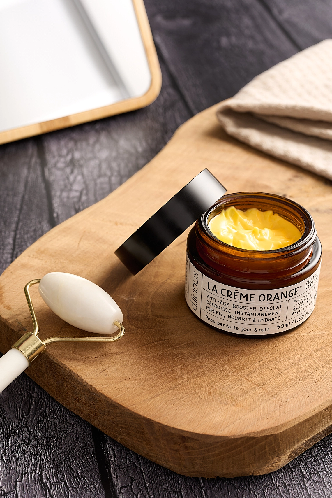 Photographie d'une crème pour le visage de couleur jaune orangé dans un decor lifestyle boisé et naturel - Photographe cosmétique - photographe lifestyle cosmétique - photographe produits cosmétiques - Aurore Aivrest
