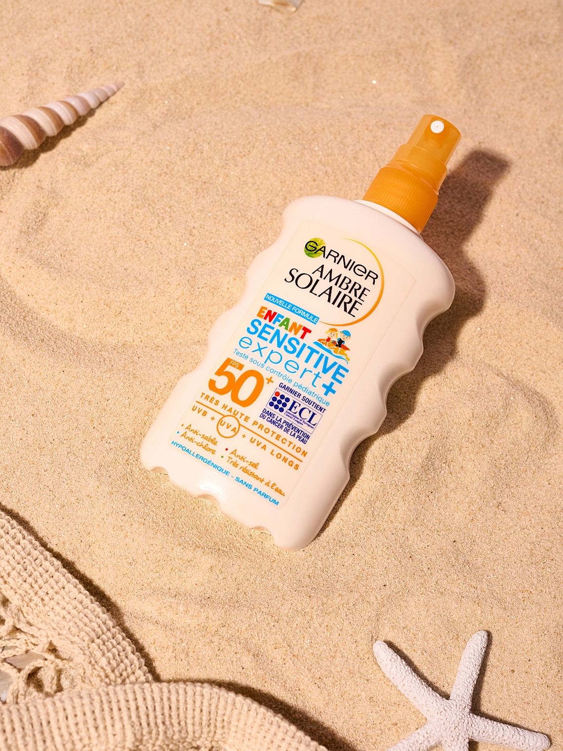 Photographie lifestyle d'une crème solaire posée dans le sable sur une plage - Photographe cosmétique - photographe lifestyle cosmétiques - photographe produits cosmétiques - Aurore Aivrest